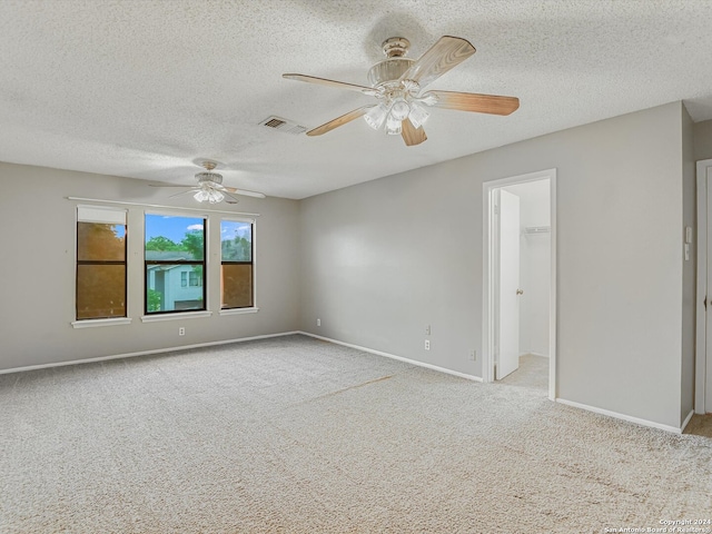 carpeted empty room featuring a textured ceiling and ceiling fan