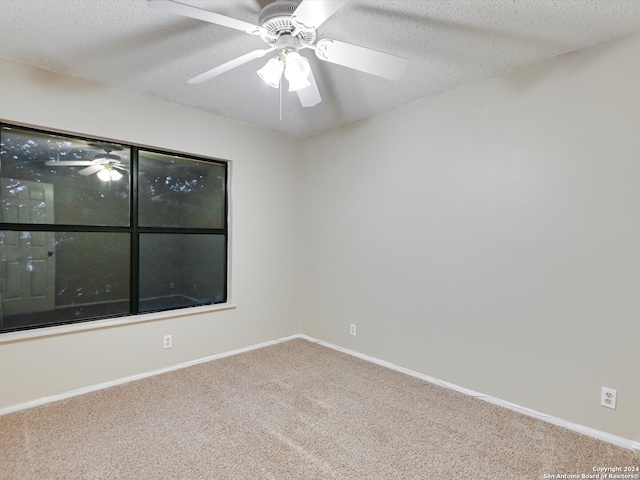 carpeted spare room with a textured ceiling and ceiling fan