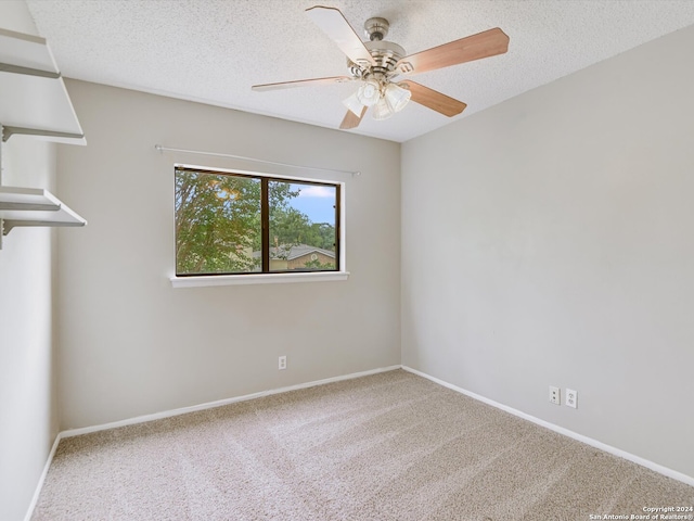 carpeted empty room with a textured ceiling and ceiling fan