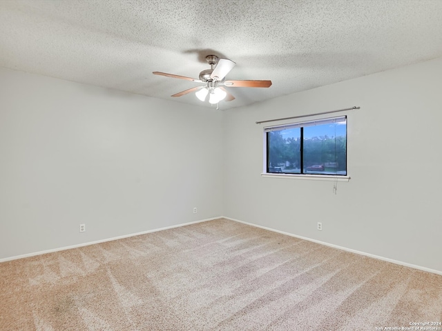 empty room featuring a textured ceiling, carpet flooring, and ceiling fan