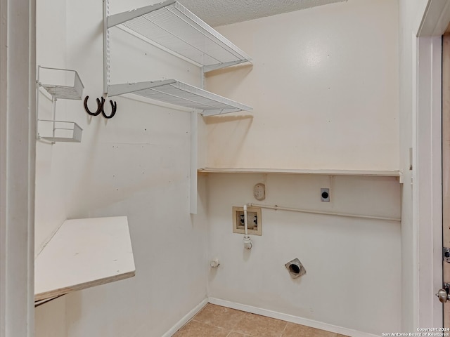 washroom with hookup for a washing machine, light tile patterned floors, electric dryer hookup, and a textured ceiling