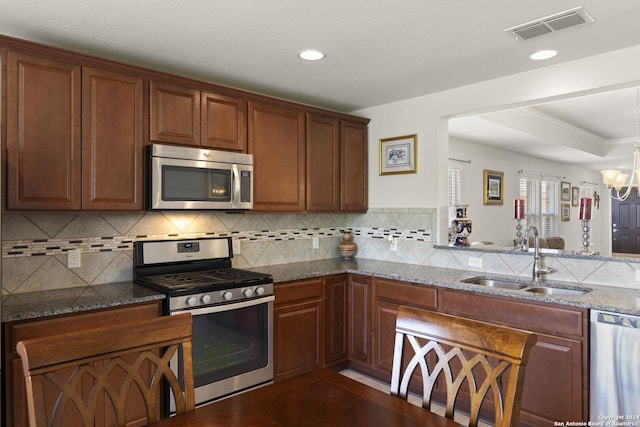 kitchen featuring stainless steel appliances, tasteful backsplash, visible vents, a sink, and a chandelier