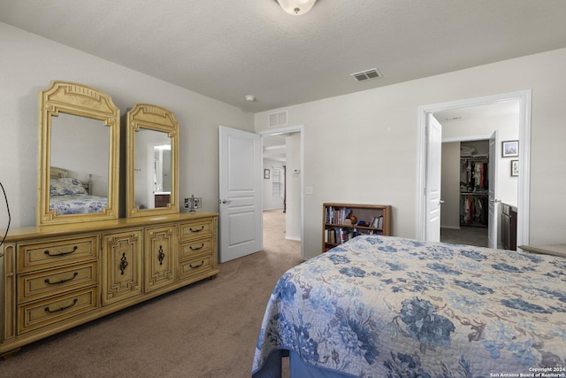 carpeted bedroom featuring visible vents and a textured ceiling