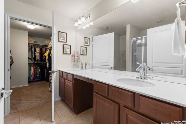 bathroom with tile patterned flooring, vanity, and walk in shower