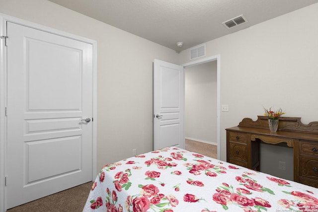 carpeted bedroom with visible vents and a textured ceiling