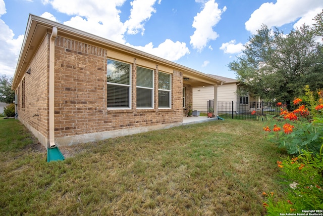 view of property exterior with a patio area and a lawn