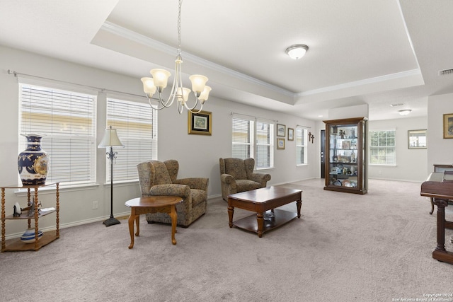 carpeted living room featuring a chandelier, a tray ceiling, ornamental molding, and baseboards