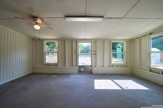 empty room with ceiling fan and concrete flooring