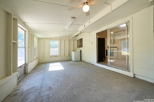 unfurnished sunroom with ceiling fan and washer / clothes dryer