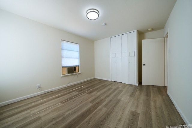 unfurnished bedroom with a closet and hardwood / wood-style floors