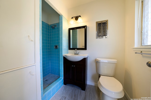 bathroom with vanity, toilet, and a tile shower