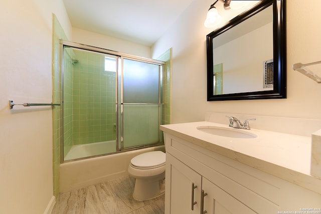 full bathroom with toilet, bath / shower combo with glass door, and vanity