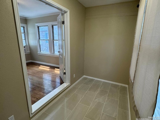 hall with light wood-type flooring and ornamental molding