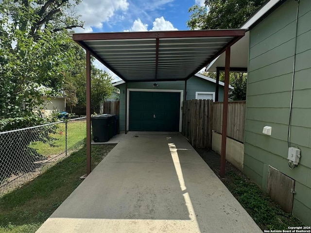 view of vehicle parking with a garage, driveway, and fence