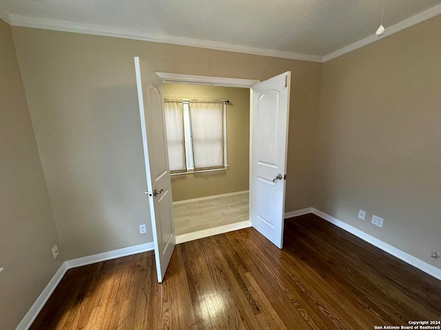 unfurnished bedroom with crown molding and hardwood / wood-style floors