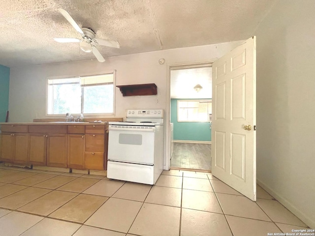 kitchen with electric range, light tile patterned flooring, and plenty of natural light