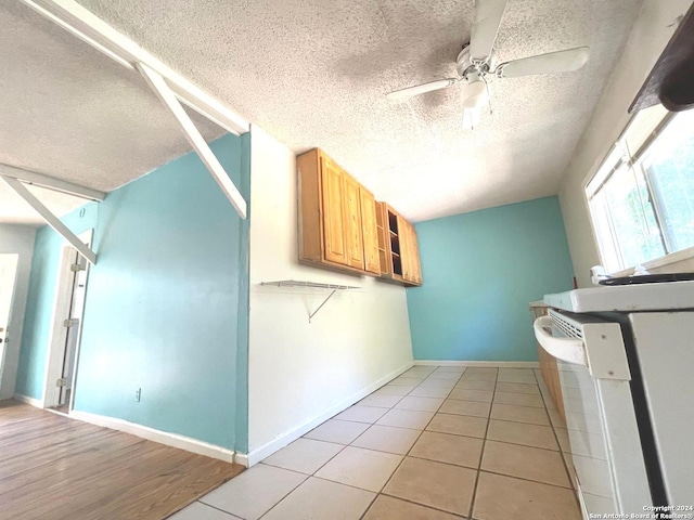 kitchen with a textured ceiling, ceiling fan, and light tile patterned floors