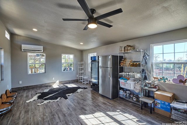 misc room featuring a wall mounted air conditioner, lofted ceiling, wood-type flooring, ceiling fan, and a textured ceiling