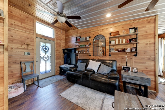 living room with wood ceiling, hardwood / wood-style floors, wood walls, and ceiling fan