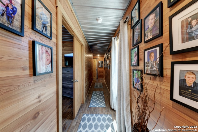 hall with wood walls and wood-type flooring