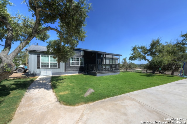 rear view of property featuring a lawn