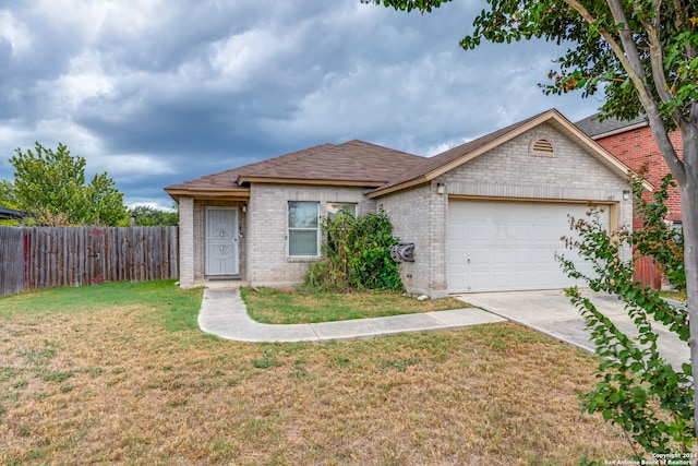 single story home featuring a garage and a front lawn