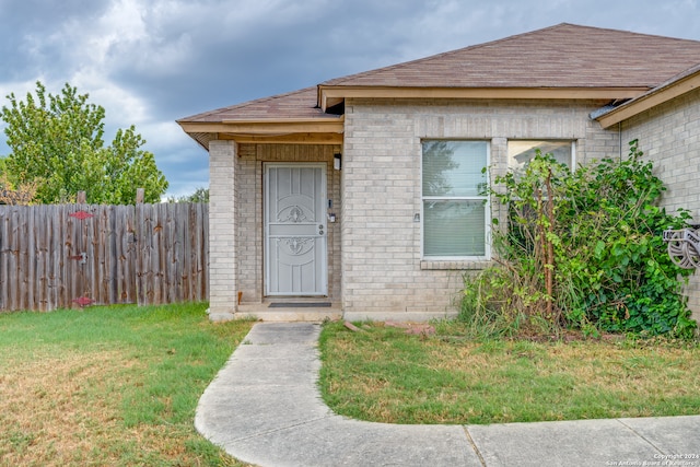 view of exterior entry with a lawn