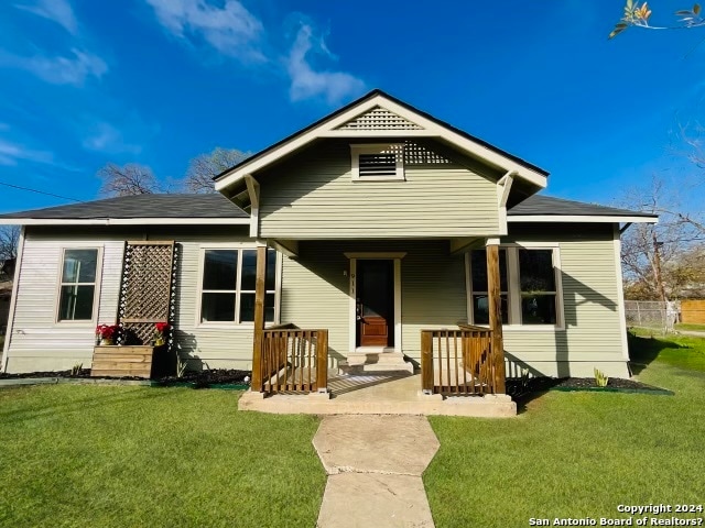 back of house featuring a lawn and a porch