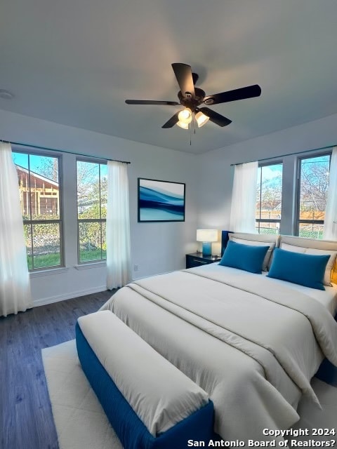 bedroom with ceiling fan, hardwood / wood-style floors, and multiple windows