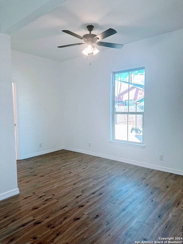 empty room with ceiling fan and dark hardwood / wood-style flooring