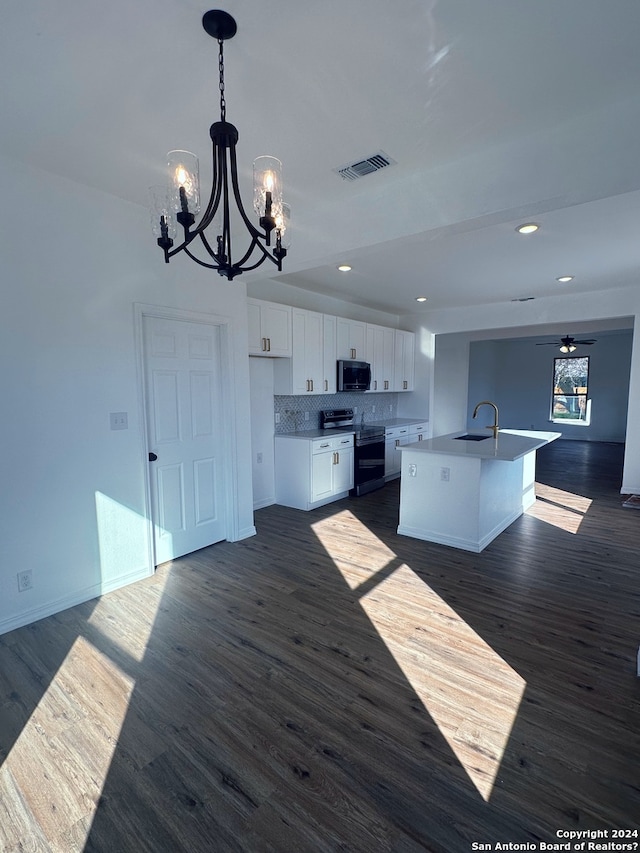 kitchen featuring ceiling fan with notable chandelier, a center island with sink, appliances with stainless steel finishes, sink, and white cabinetry