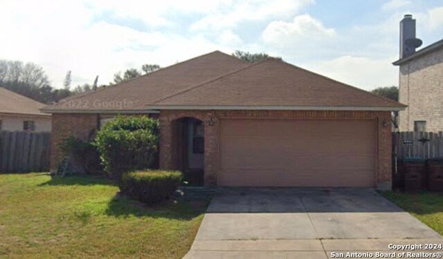 ranch-style home with a garage and a front yard