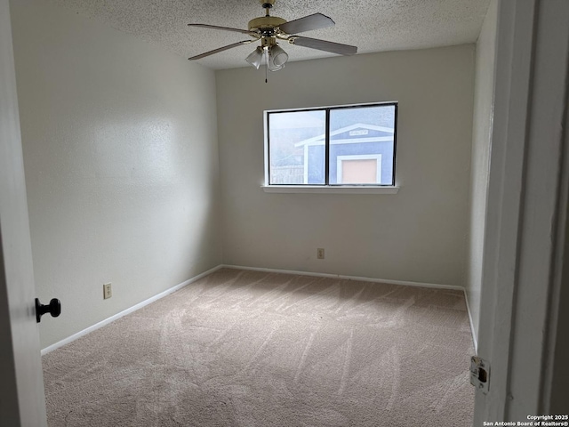 carpeted spare room with ceiling fan, baseboards, and a textured ceiling