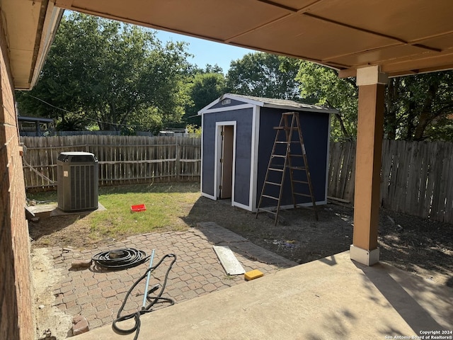 view of shed featuring a fenced backyard and central AC unit