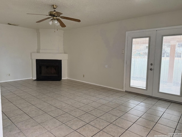 unfurnished living room featuring french doors, a fireplace, light tile patterned floors, visible vents, and a textured ceiling