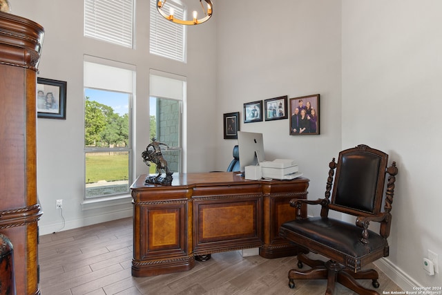 office area featuring wood-type flooring and a chandelier