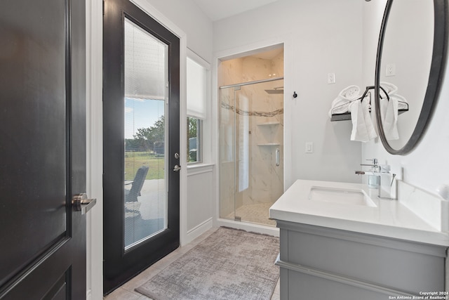 bathroom with tile patterned flooring, walk in shower, and vanity