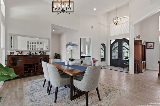 dining room featuring a high ceiling, wood-type flooring, and a chandelier