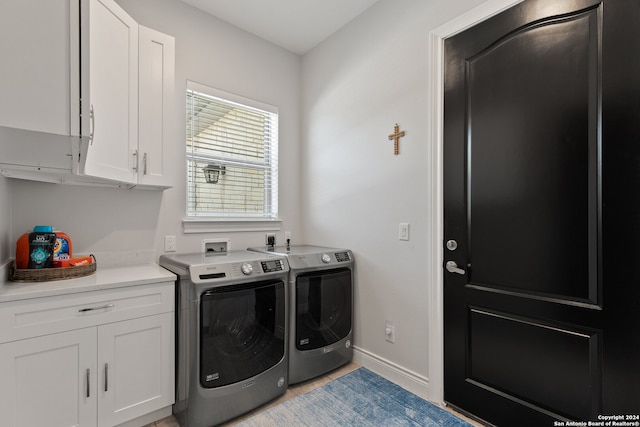 clothes washing area featuring cabinets and washing machine and dryer