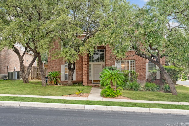 view of front of house featuring a front lawn and central air condition unit