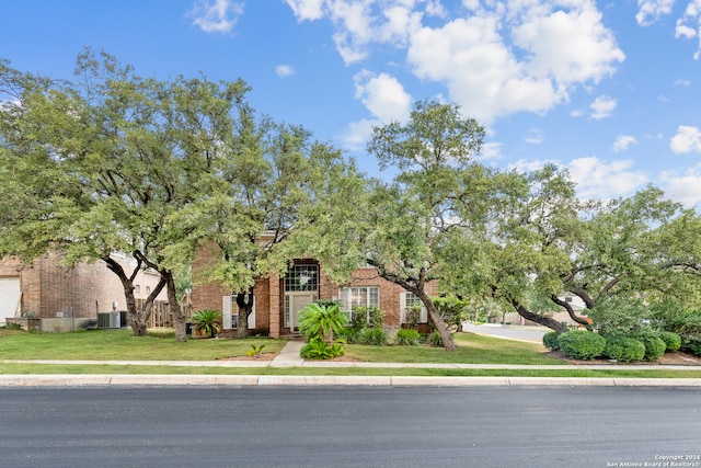 obstructed view of property with a front lawn and central air condition unit