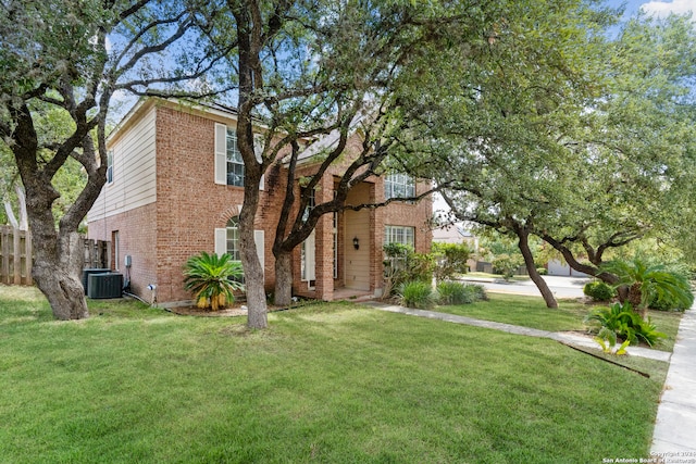 view of front of property with a front lawn and central AC