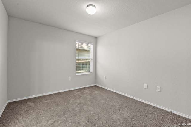 unfurnished room with a textured ceiling and carpet floors