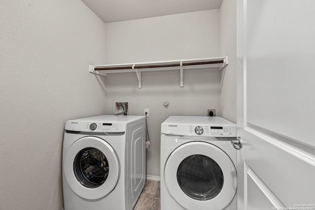 washroom featuring light hardwood / wood-style flooring and washing machine and clothes dryer