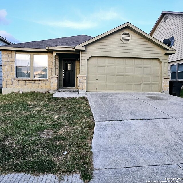 ranch-style house featuring a front yard and a garage