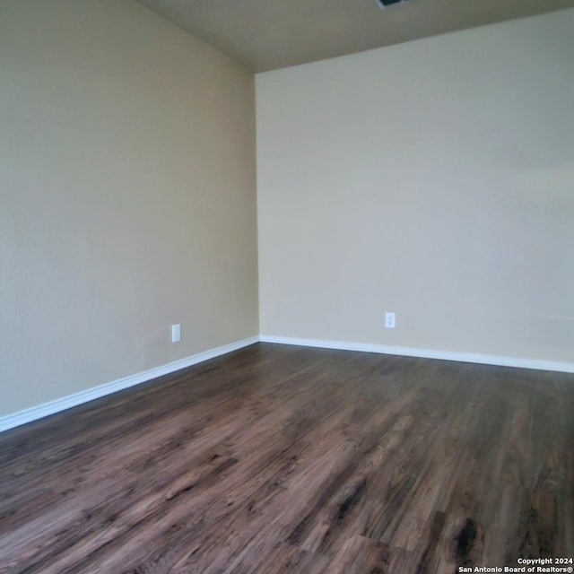 empty room with dark wood-type flooring