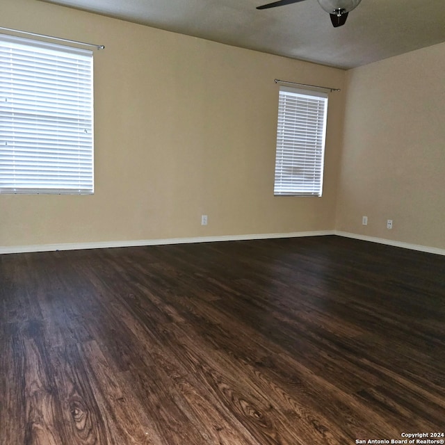 unfurnished room with dark wood-type flooring and ceiling fan