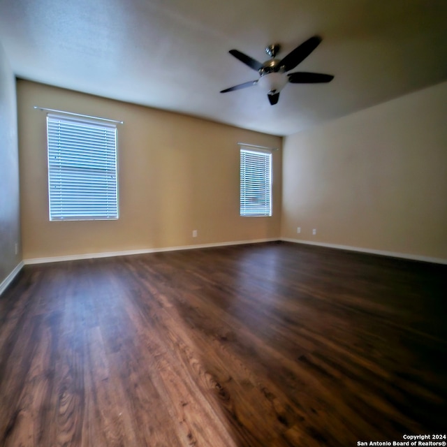 empty room with dark wood-type flooring and ceiling fan