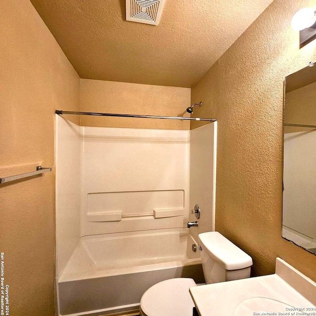 full bathroom with shower / bath combination, toilet, a textured ceiling, and vanity