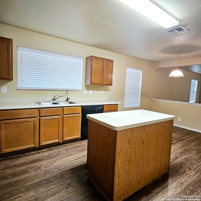 kitchen featuring dishwasher, sink, dark hardwood / wood-style floors, a kitchen island, and a textured ceiling